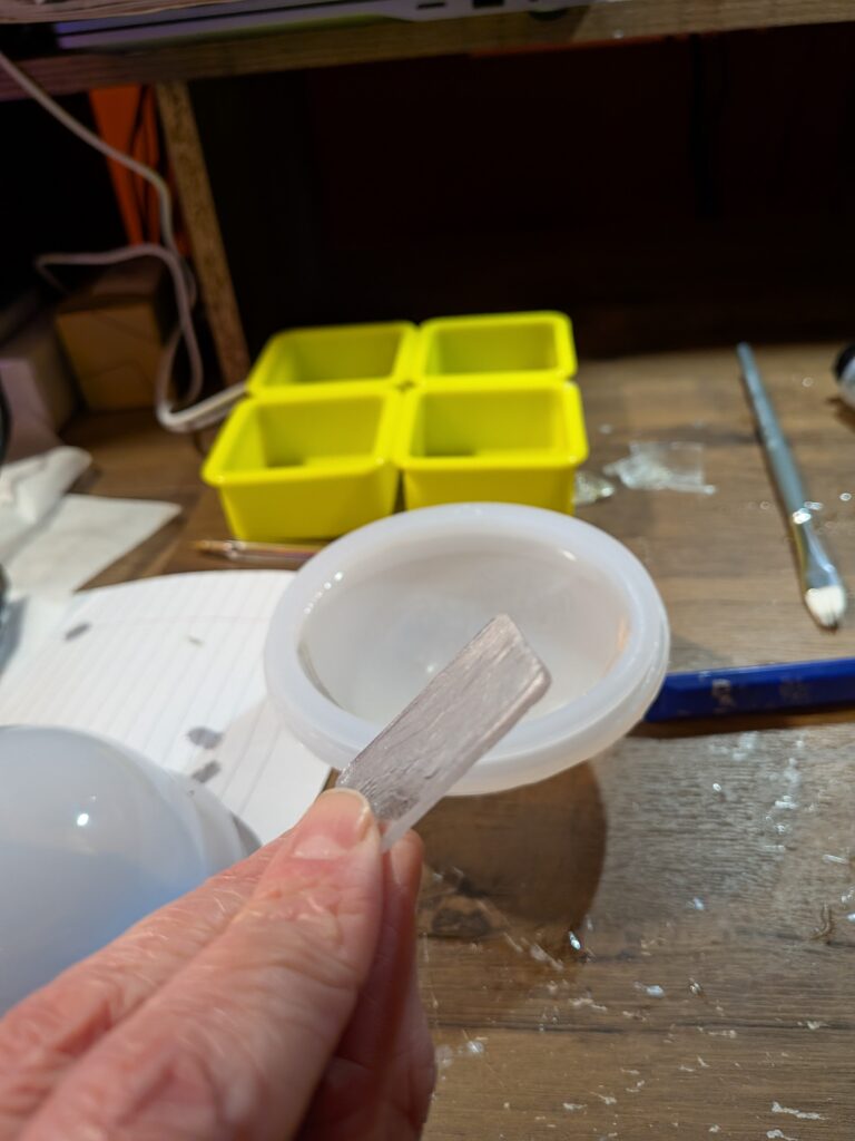 Bottom of deep pour resin sphere with 24-hour cure epoxy phone screen held in front. 